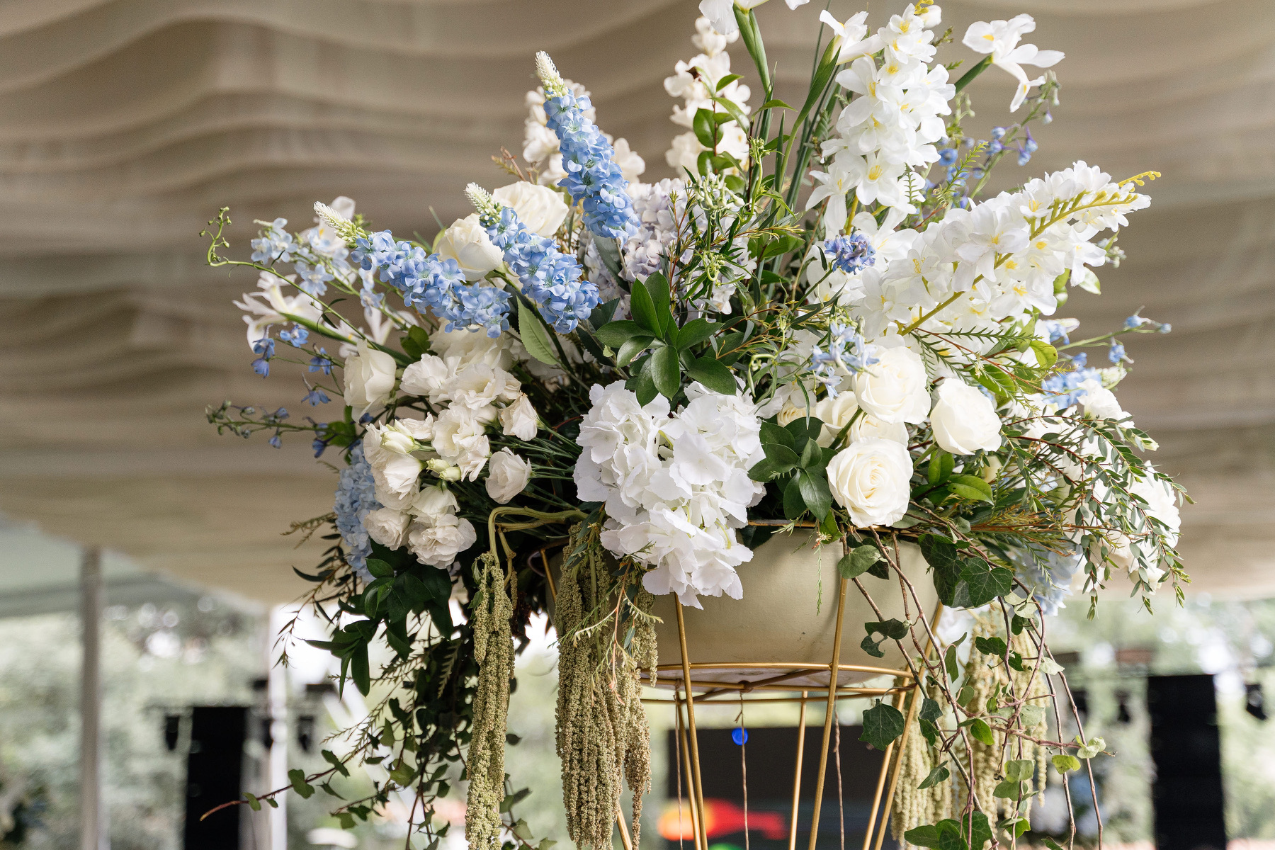Desk with leather desk pad, walnut desk organizer, wireless keyboard and mouse, and porcelain mug.