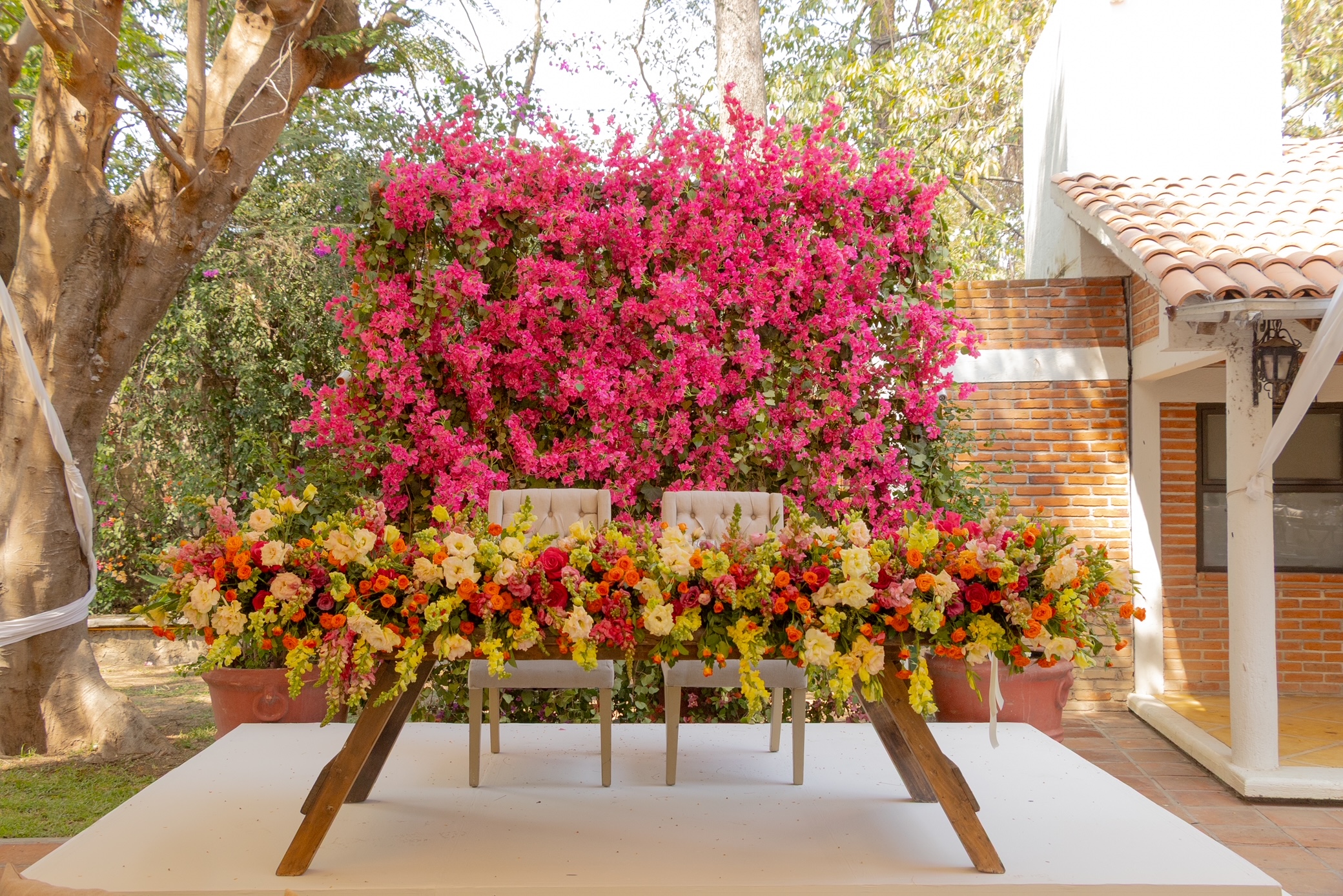 Desk with leather desk pad, walnut desk organizer, wireless keyboard and mouse, and porcelain mug.