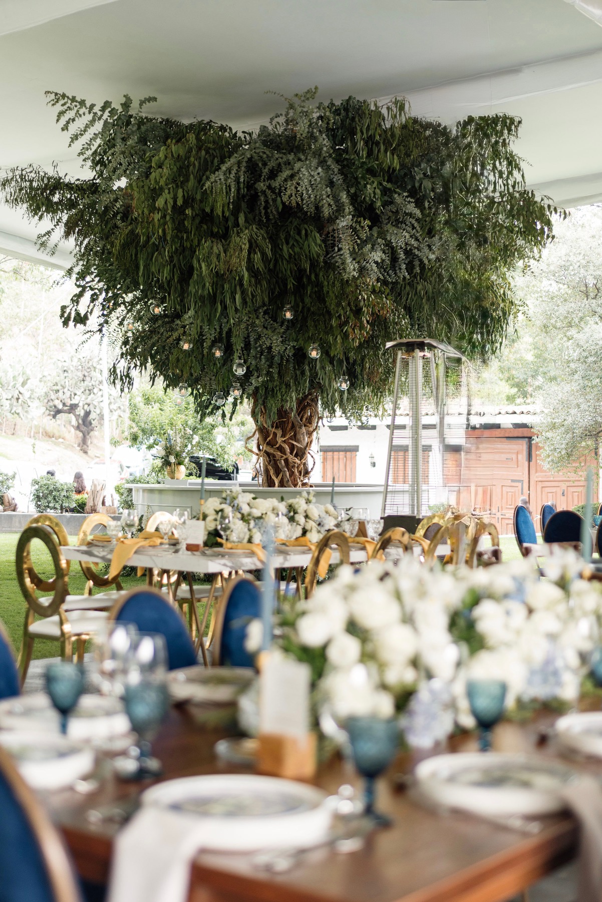 Desk with leather desk pad, walnut desk organizer, wireless keyboard and mouse, and porcelain mug.