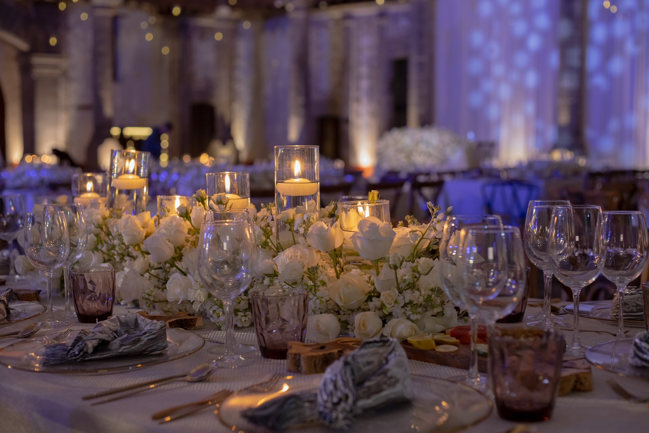 Desk with leather desk pad, walnut desk organizer, wireless keyboard and mouse, and porcelain mug.