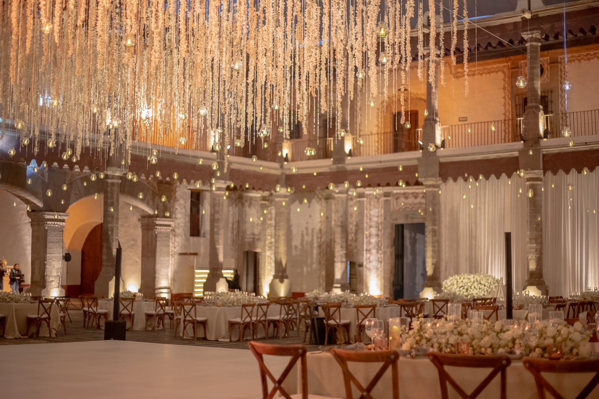 Desk with leather desk pad, walnut desk organizer, wireless keyboard and mouse, and porcelain mug.