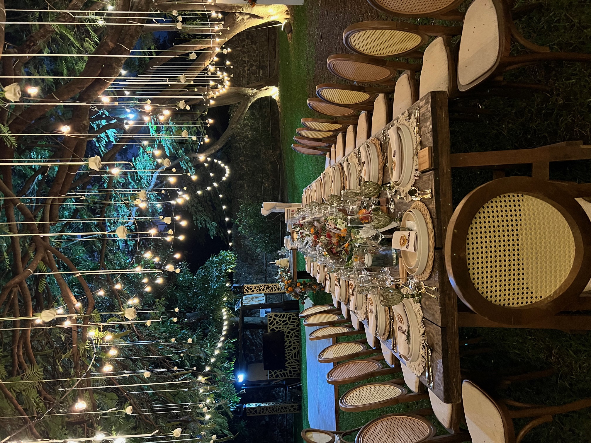 Desk with leather desk pad, walnut desk organizer, wireless keyboard and mouse, and porcelain mug.