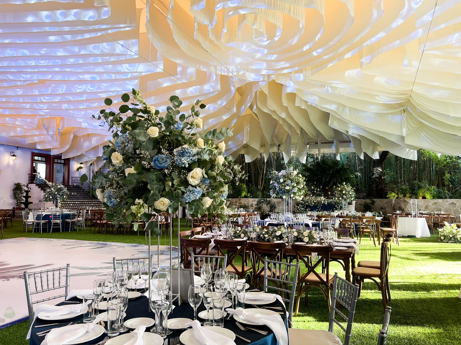 Desk with leather desk pad, walnut desk organizer, wireless keyboard and mouse, and porcelain mug.